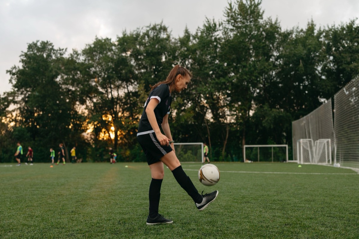 A young person practising football skills on a pitch